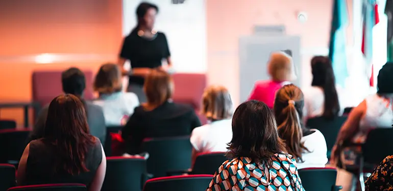 Image of a speaker in front of a group of young professionals